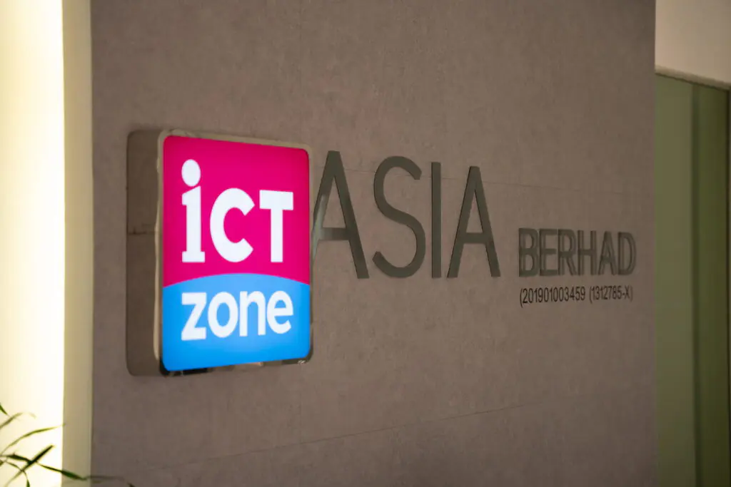 ICT Zone Asia Berhad logo signage on an office wall