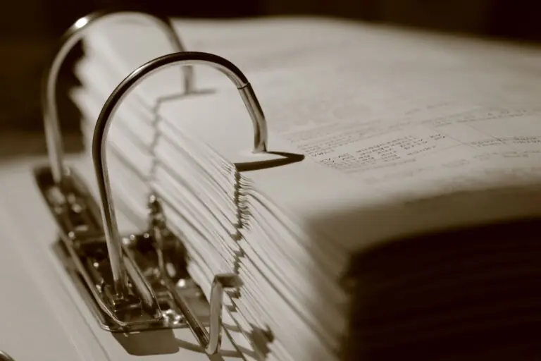 Close-up of an open ring binder filled with documents, in sepia tone