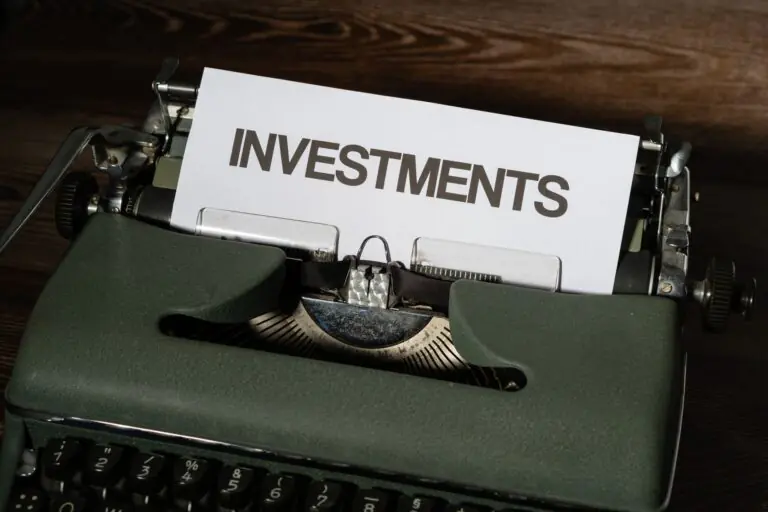 A green vintage typewriter with a sheet of paper reading "Investments"