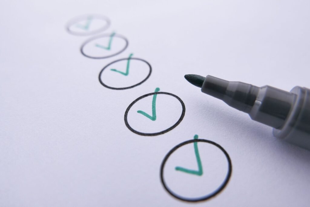 A marker pen beside a row of circles with green check marks on white paper