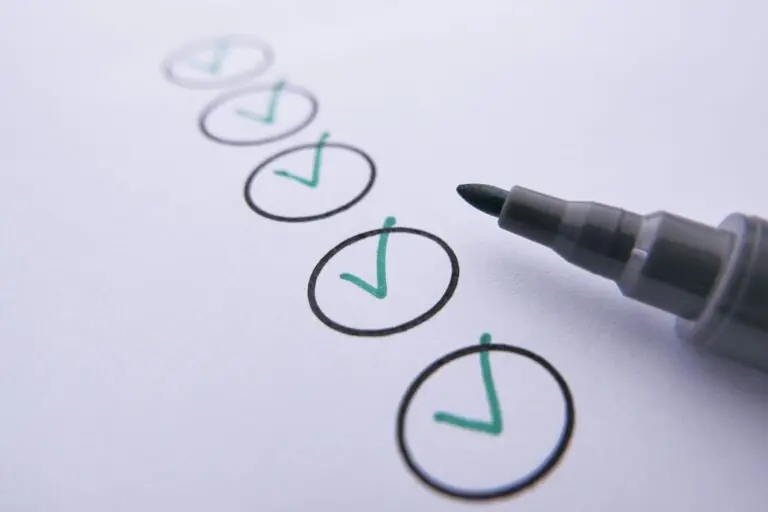 A marker pen beside a row of circles with green check marks on white paper